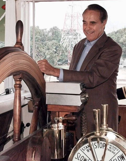 Bob Dole standing in front of a clock